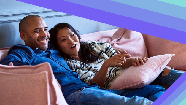 A happy couple watching TV and discussing